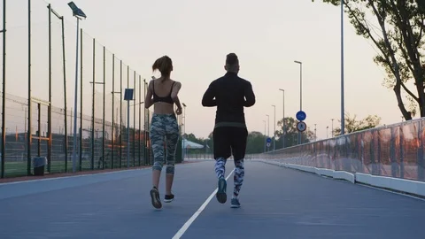 Rear view of a couple jogging Stock Footage 100033239