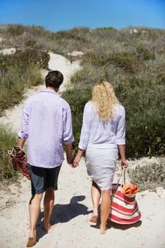 Rear view of a couple walking on the beach Stock Photos