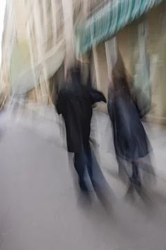 Rear view of couple walking down street, blurred motion Fotos Stock