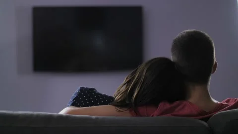Rear view of couple watching television at night Stock Footage