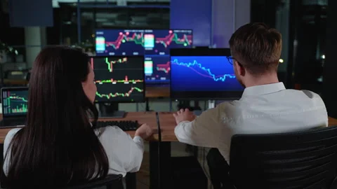 Rear view of creative team of cryptocurrency traders analyzing bitcoin graphs Stock Footage 266465889
