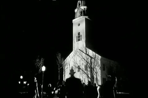 Rear view crowd rushing to church at night Stock Footage