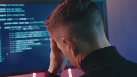 Rear view of developer having stress in the office. Man programmer has a Stock Footage 139661948