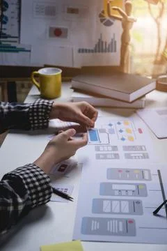 Rear view developer ux and ui designer about mobile phone app and choosing some Foto stock