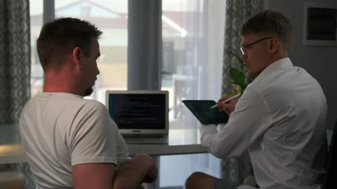 Rear view developers review and refine code together in the office. Stock Footage 294298720