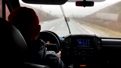 Rear view of the driver driving a car.view through the windshield on the road in Stock Footage 229832086