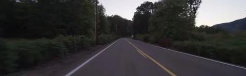 Rear view of a Driving Plate: Car travels at dusk past farms and vineyards on Stock Footage 59330117