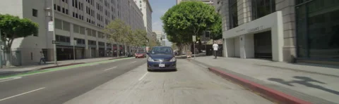 Rear view of a Driving Plate: Car travels on Spring Street in Los Angeles, turns Stock Footage 59356568