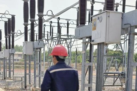 Rear view of electrical engineer worker with red safety helmet inspecting h.. Stock Photos