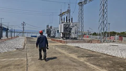 Rear view of electrical engineer worker with red safety helmet . Stock Photos