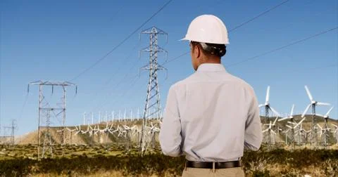 Rear view of Engineer checking on wind turbines for renewable energy Stock Photos