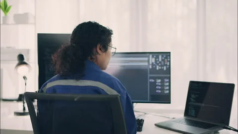 Rear View of Female Developer Coding at Multi-Screen Tech Workstation. Stock Footage 307587168