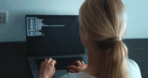 Rear view of female programmer developer looking at computer monitor and writing Stock Footage 243355204