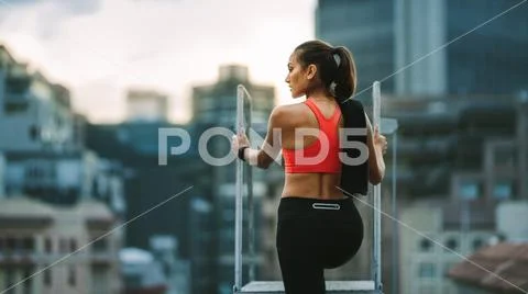 Rear view of a fitness woman standing on rooftop staircase Stock Photos