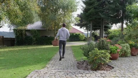 Rear view of full length young man walking out of house Stock Footage 162774167