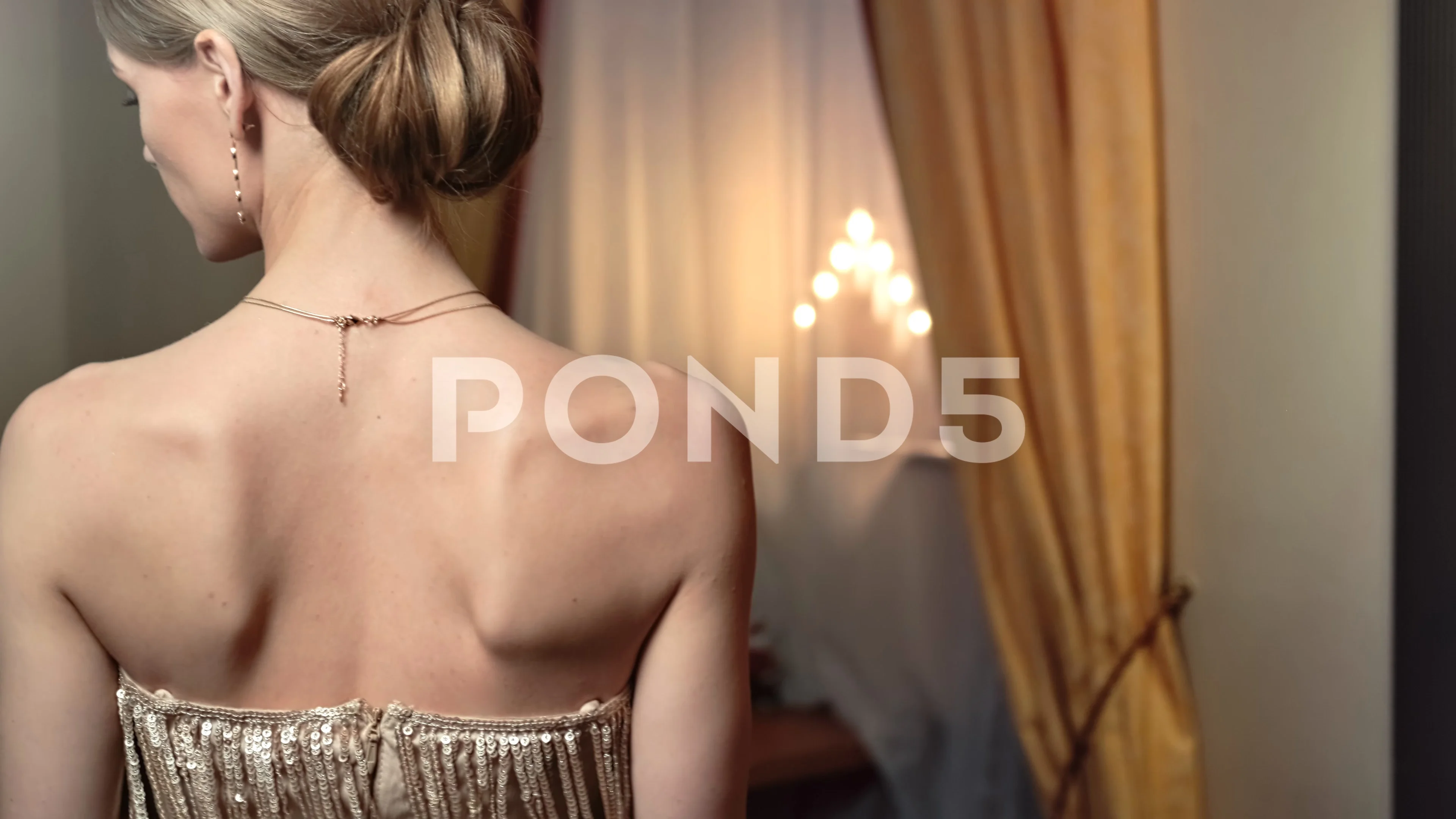 Rear view girl with naked shoulders walking at luxury interior close up.  Wide