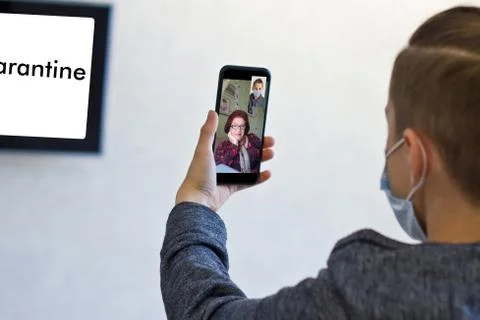 Rear view of a guy talking on a video call with a smiling elderly grandmother Stock Photos