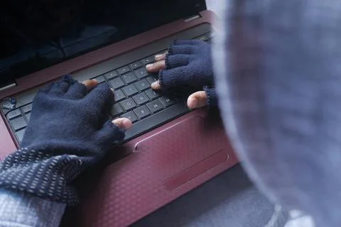 Rear view of hacker hand stealing data from laptop top down Stock Photos