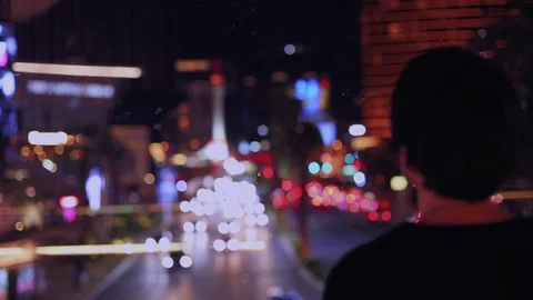 Rear view handheld shot of man watching illuminated streets of city Vídeo Stock 114841950