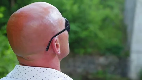 Rear view of the head of a bald man in sunglasses. Close up shot. Stock Footage 115025427