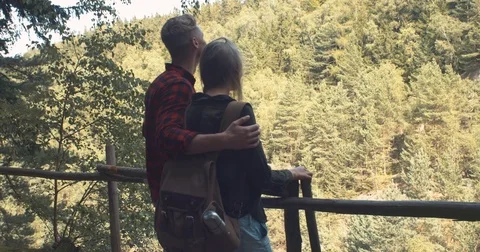 Rear view of hugging couple standing on a hill in a forest. Stock Footage 80796949