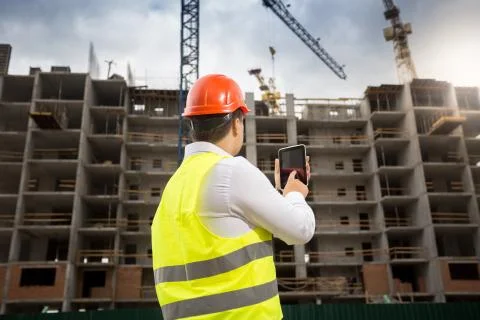Rear view image of construction engineer using digital tablet on building site Foto stock