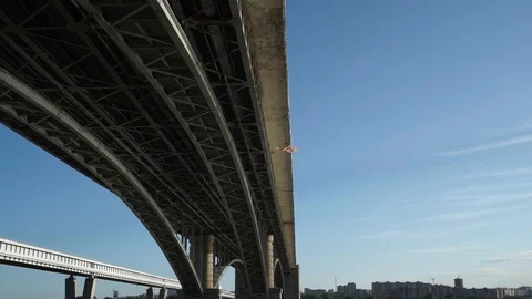 Rear view of a kite flying high in the blue sky under a bridge. Bird's-eye view. Stock Footage 110924262