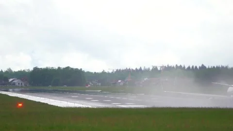 Rear view of a large jet landing on a long, wet runway Stock Footage 241148896