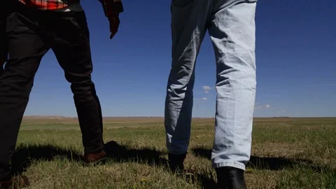 Rear view lockdown shot of four people walking away in the desert 스톡 동영상 114884868