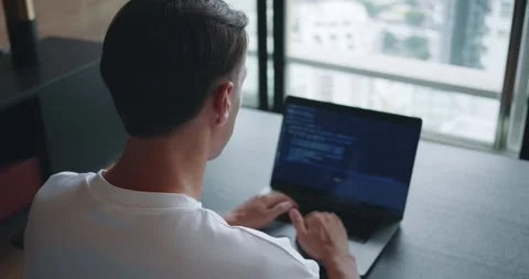 Rear view male 30s coding on laptop screen. Man look at laptop screen, hands Stock Footage 252377659