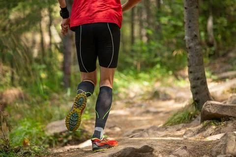 Rear view male runner in compression socks running Stock Photos