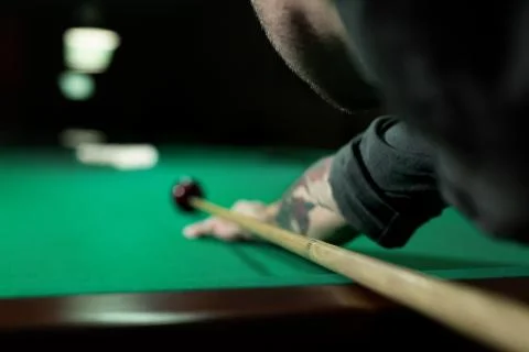 Rear view of man aiming the billiard ball with cue. Фото
