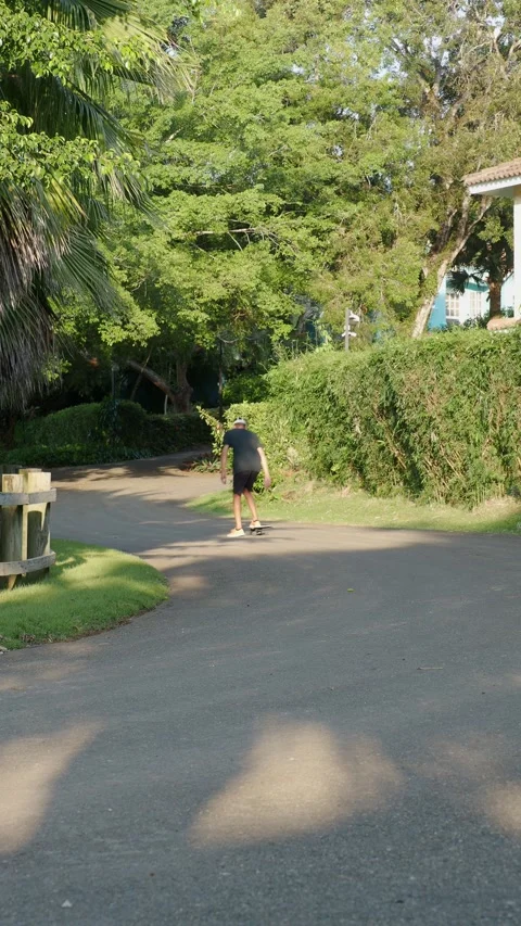 Rear view of man in augmented virtual reality goggles riding skateboard outside. Stock Footage 269988231