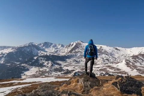Rear view of man with backpack looking at snow capped mountain peak Zirbitz.. Stock Photos