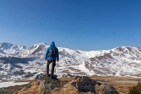 Rear view of man with backpack looking at snow capped mountain peak Zirbitz.. Foto stock