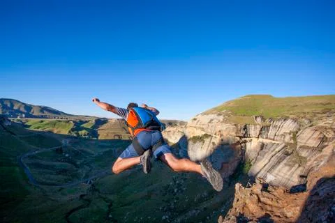 Rear view of man BASE jumping from mountain Foto stock