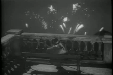 Rear view of man on bench watching fireworks from terrace Stock Footage 11352953