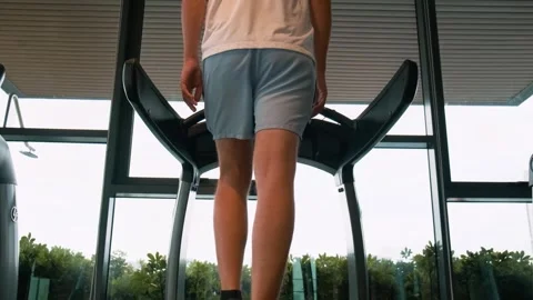 Rear view of man doing cardio training in fitness studio in residental building Stock Footage 280942574