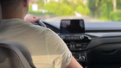 Rear view of man driving car on road Stock-Footage 336748680