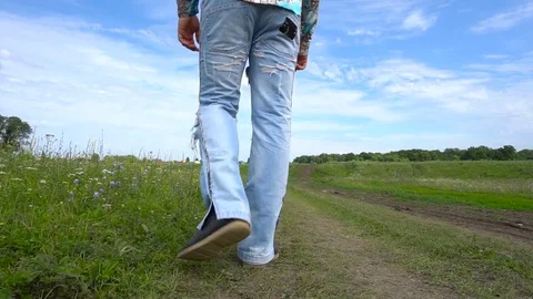 Rear view. Man go away through the field Stock Footage 79600502