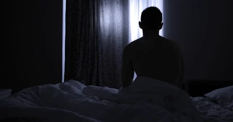 Rear view of man going to bed at night Stock Footage