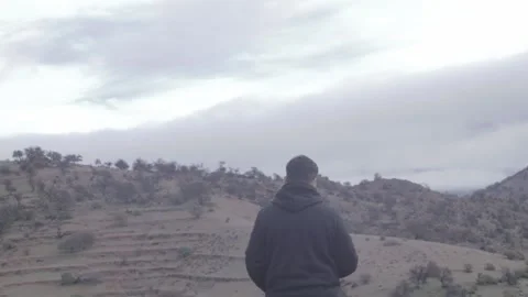 Rear View Man In Hoodie Looking At Foggy Mountains In Morocco Stock Footage 332776547