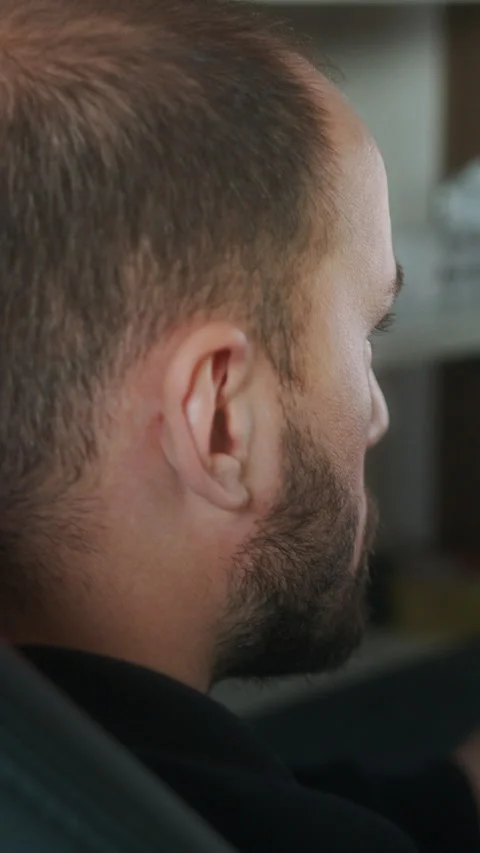 Rear view of a man intently looking at a large computer monitor in a home o.. Stock Footage 328331545