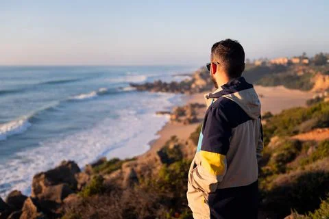 Rear view of a man with jacket looking at the sea Stock Photos