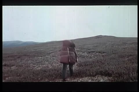 Rear view of man with large backpack hiking across mountain Stock Footage 11354797