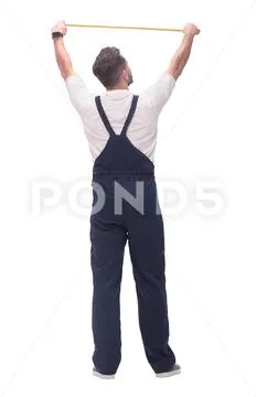 Rear view. a man measuring something with a construction tape measure. Stock Photos