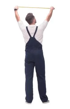 Rear view. a man measuring something with a construction tape measure. Stock Photos