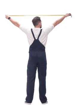 Rear view. a man measuring something with a construction tape measure. Stock Photos