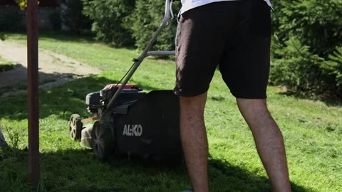 Rear view of a man mowing the grass, 11 September 2021, Ternopil, Ukraine Stock Footage 165552838