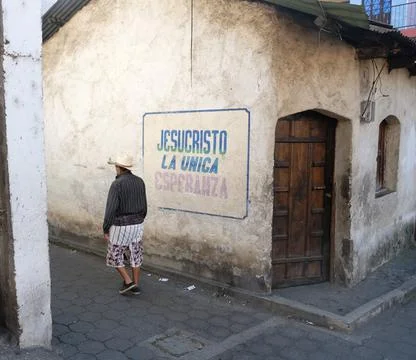 Rear view of the man near the house wall with the text "Jesucristo la unica espe Stock Photos